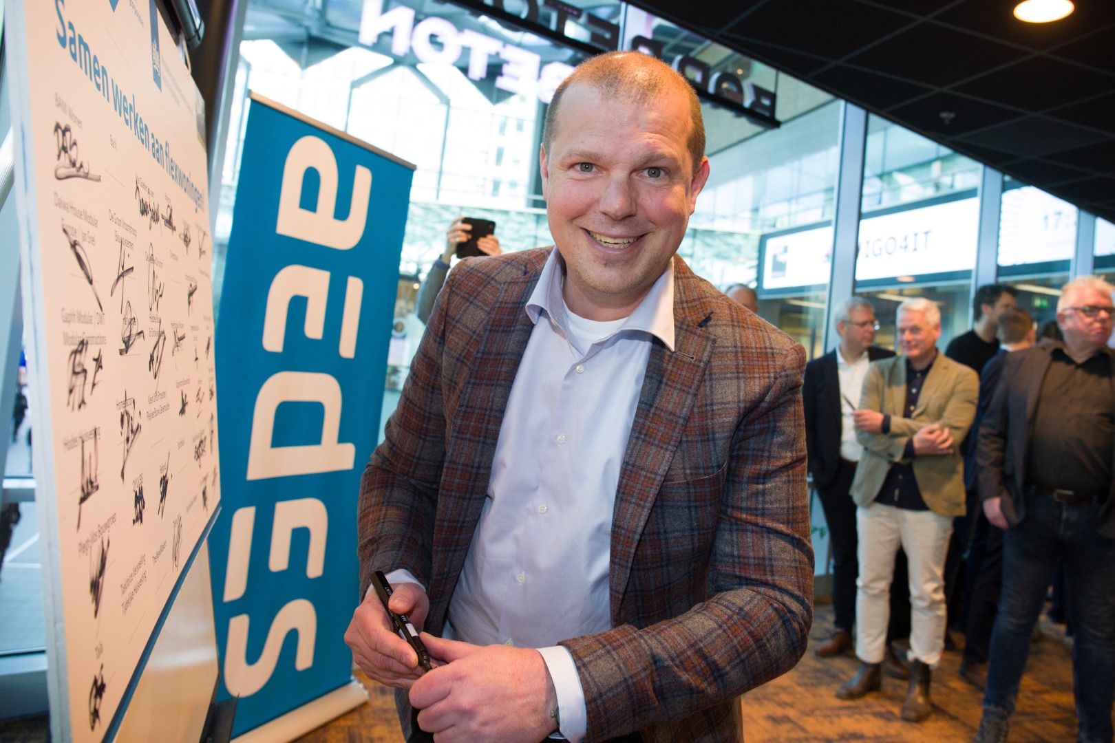 Namens QYUUBS ondertekent Bardo Mutsaers de overeenkomst met AEDES voor de levering van flexibele woningen.